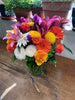 Lush and full and bright and colorful cut flower arrangement in a 5x8 inch cylinder vase